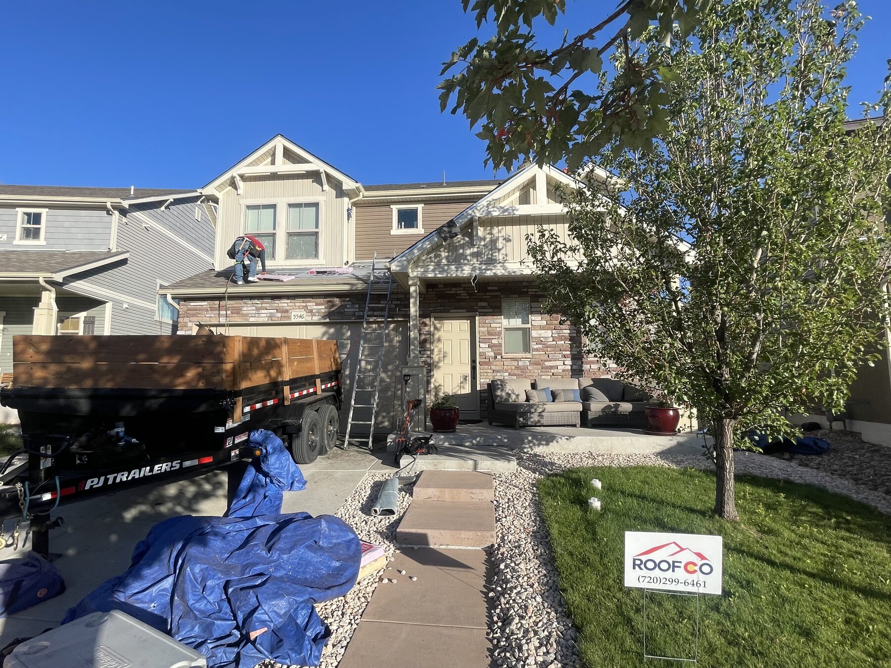 Roofco yard sign and crew on Denver-area home